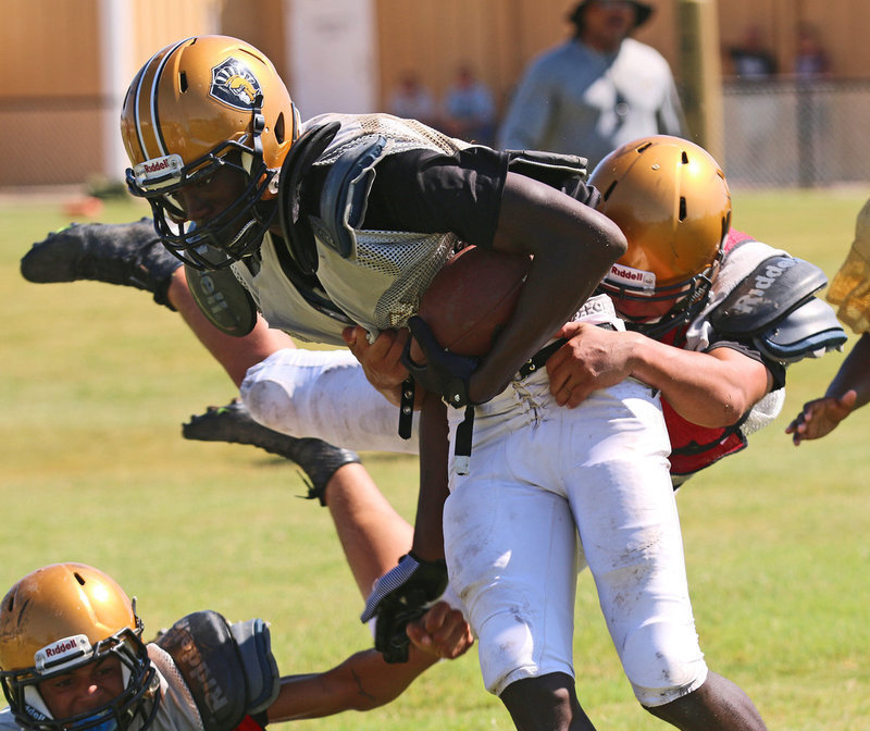 Image: Chasston WIlson #1 fights off tacklers as he rumbles for positive yards.