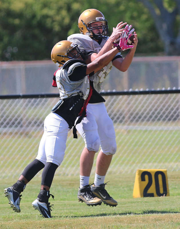 Image: James Walton #45 pulls in a pass despite tight coverage from Kendrick Norwood #86.