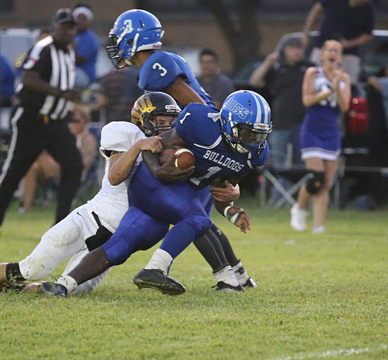Image: Milford’s #1 Taron Smith drags an Eagle defender as far as he possibly can down the field as Bulldog teammate #3 Damyan Woodward looks to throw another block at the flock.