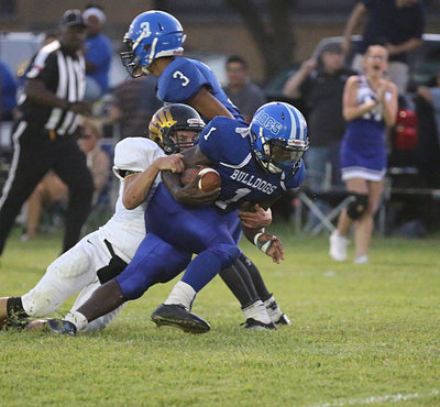 Image: Milford’s #1 Taron Smith drags an Eagle defender as far as he possibly can down the field as Bulldog teammate #3 Damyan Woodward looks to throw another block at the flock.