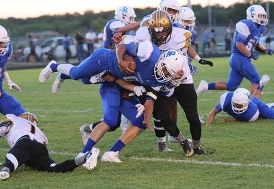 Image: Gladiator defender #1 Kevin Johnson upends a Lion running back as teammate #8 Joe Celis arrives to add the finishing touches.